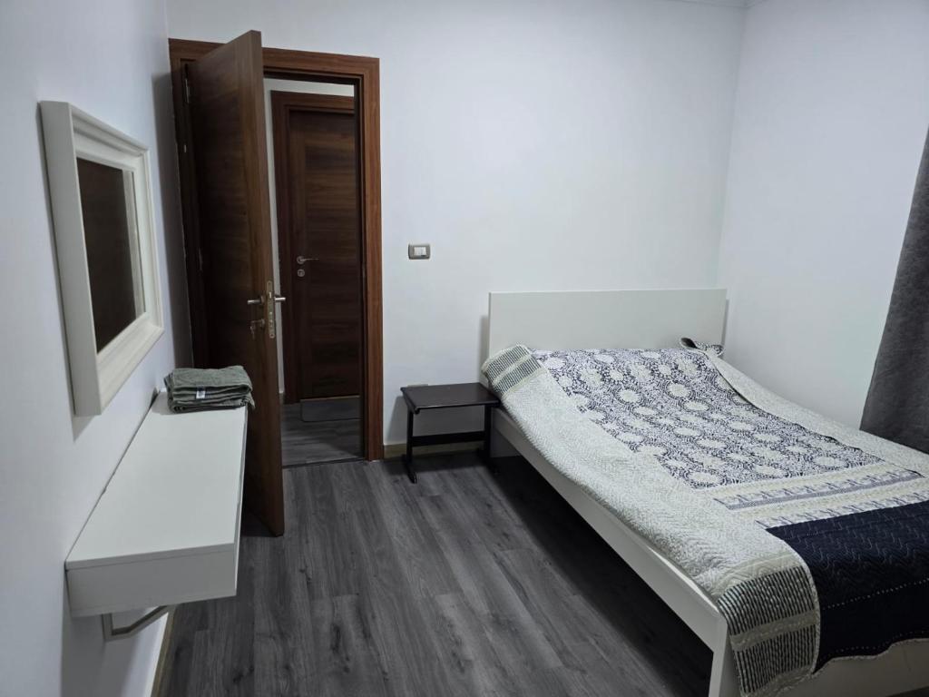 een slaapkamer met een bed, een bureau en een raam bij El-Shaikh Zayed, 6 october 3BHK flat- families only in Sheikh Zayed