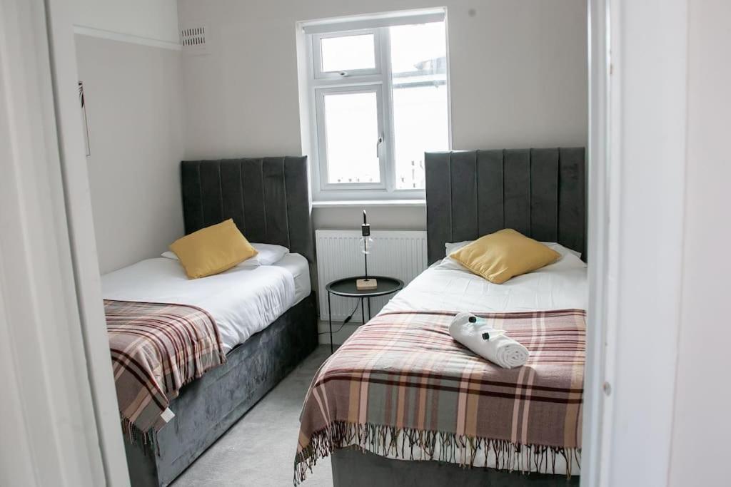 a bedroom with two beds and a window at Coastal Haven in Leigh-on-Sea in Southend-on-Sea