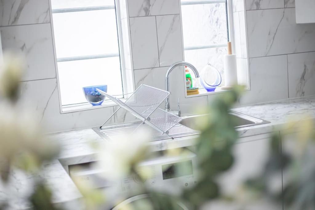 a kitchen sink with a faucet next to a window at Coastal Haven in Leigh-on-Sea in Southend-on-Sea