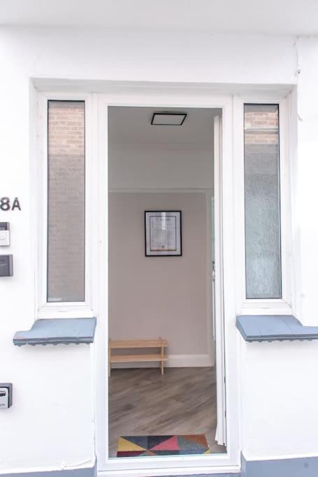a white room with two windows and a hallway at Coastal Haven in Leigh-on-Sea in Southend-on-Sea