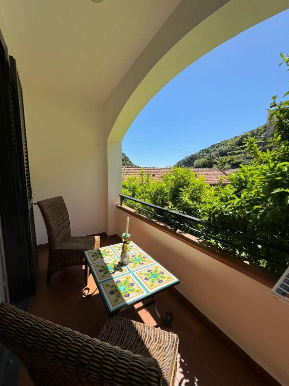 a table and chairs in a room with a window at Jungle Rooms in Cetara