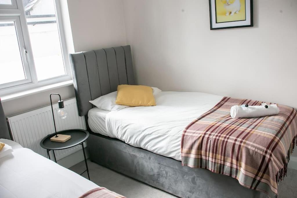 a small bedroom with a bed with a yellow pillow at Coastal Haven in Leigh-on-Sea in Southend-on-Sea