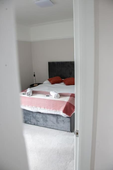 a bedroom with a bed with red pillows at Coastal Haven in Leigh-on-Sea in Southend-on-Sea