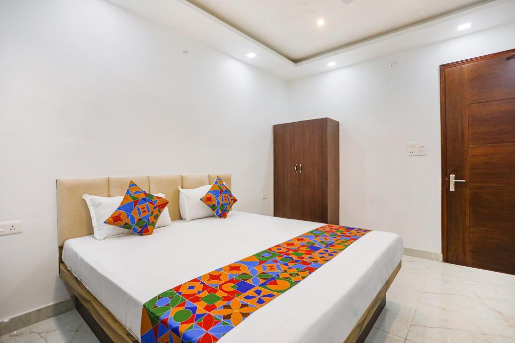 um quarto com uma cama com um cobertor colorido em FabHotel JP Villa em Varanasi