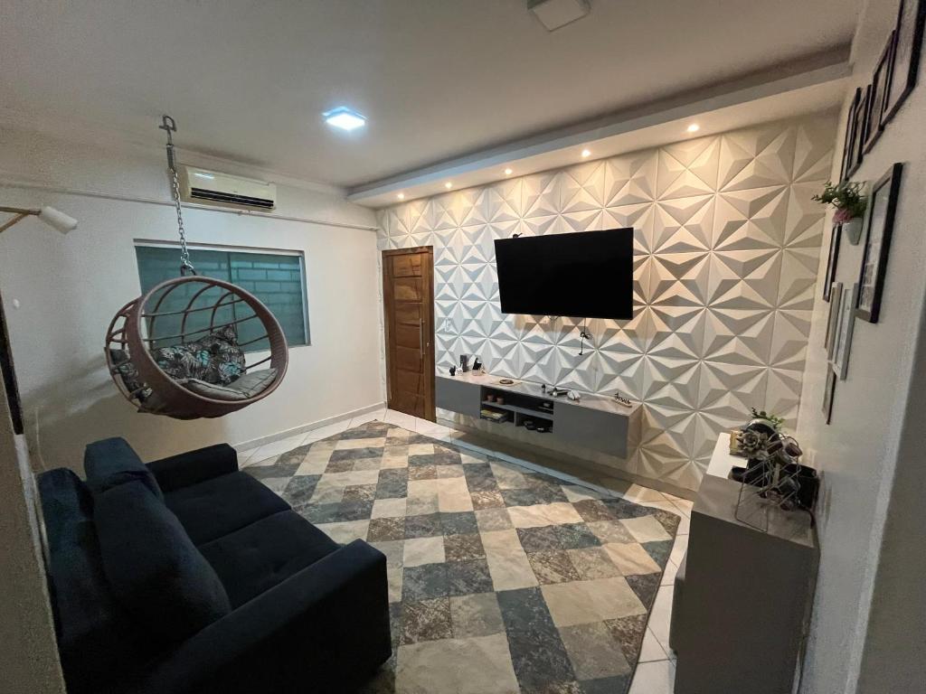 Apartamento completo e elegante, BEM LOCALIZADO. في بوتو فيلهو: غرفة معيشة مع أريكة وتلفزيون بشاشة مسطحة
