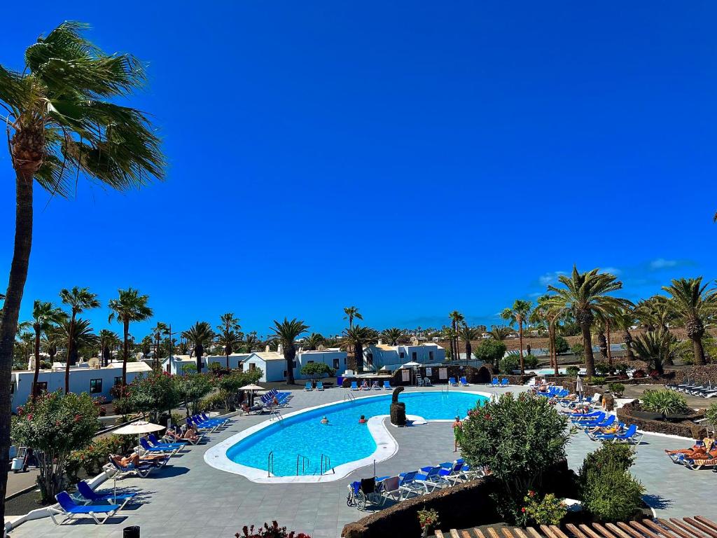 een uitzicht op een resort met een zwembad en palmbomen bij Casas del Sol in Playa Blanca