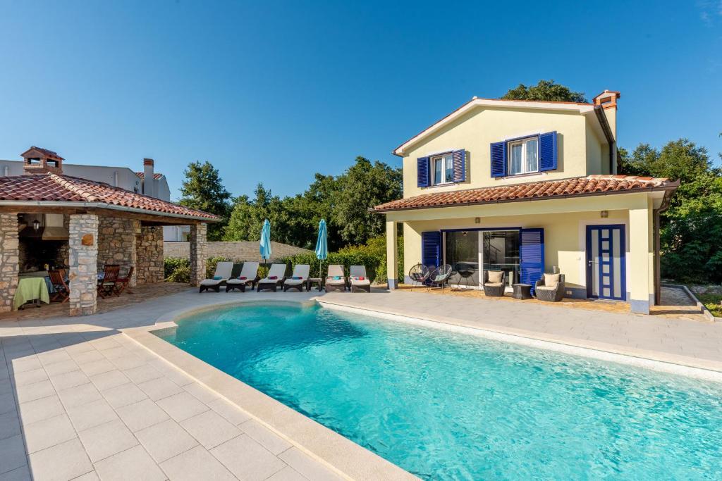 una villa con piscina frente a una casa en Villa Rose near Labin - Rabac for 4 people with playground and private pool, en Kršan