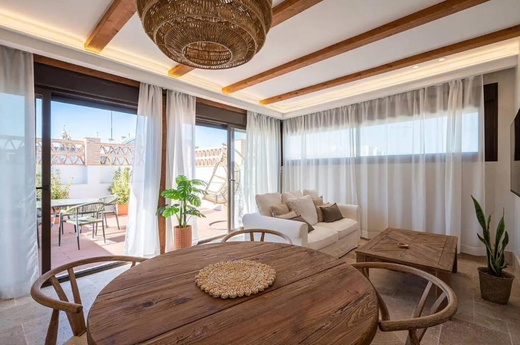 un soggiorno con tavolo e sedie in legno di Arcos de Medina - Apartamentos premium a Cordoba
