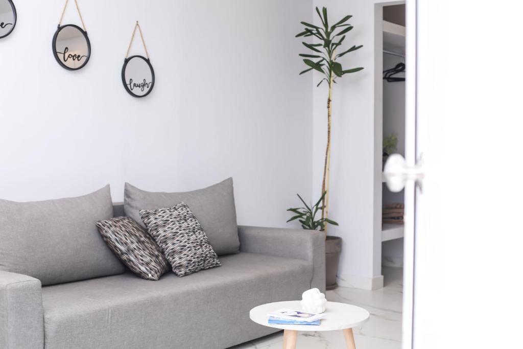 un salon avec un canapé gris et une table dans l'établissement Sol Apartments Corfu by Estia, à Corfou