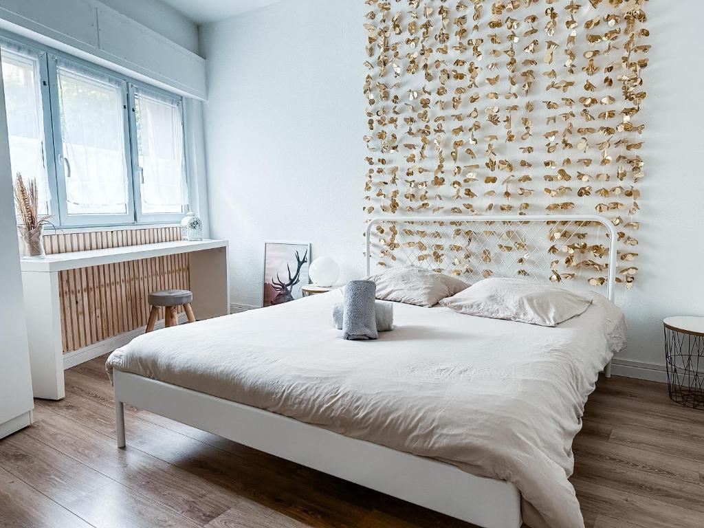 une chambre avec un grand lit avec un mur de fleurs dans l'établissement Le 16 - Charmant appartement proche du centre ville, à Strasbourg