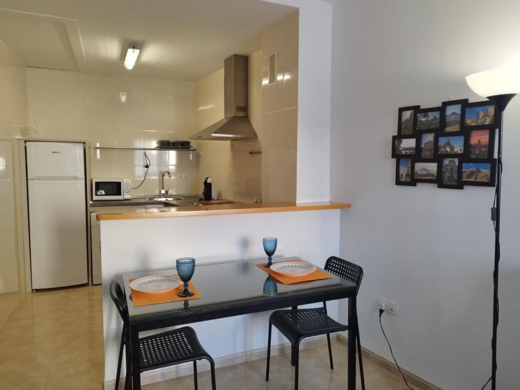cocina con mesa, 2 sillas y barra en Apartamento Santa Clara Centro, en Antequera