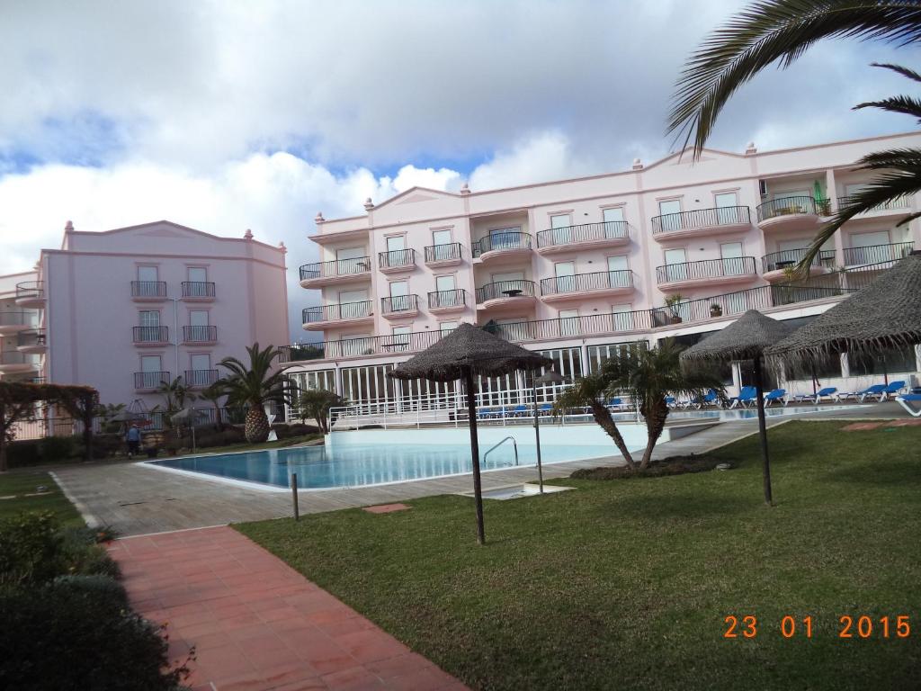a hotel with a swimming pool in front of a building at St James Apartment in Luz