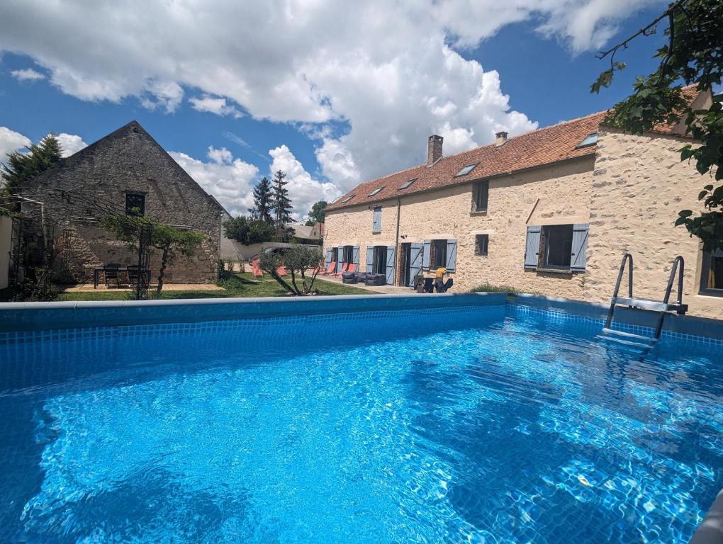 uma grande piscina em frente a uma casa em Le Clos de L'Olivier 