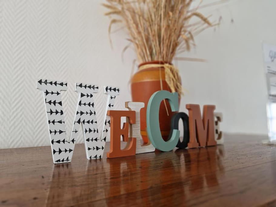 un panneau qui dit amour assis sur une table avec un vase dans l'établissement Appartement Comme à la maison, à Le Breuil