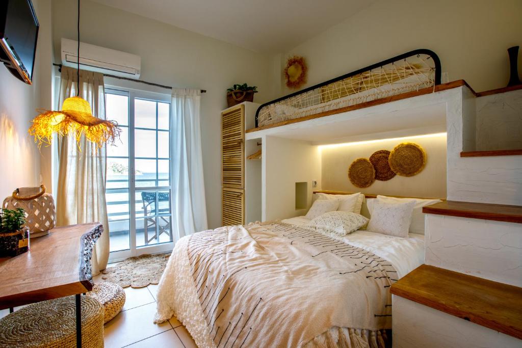 トロにあるArcadia Luxury Rooms Seaside Cuisineの大きなベッドとバルコニーのある寝室