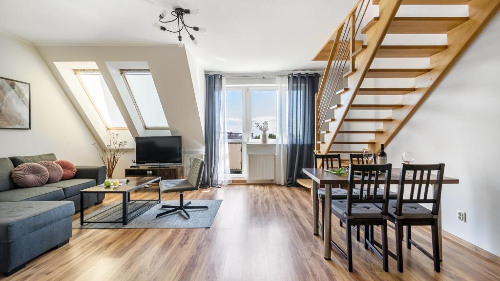 Una sala de estar con un sofá y una escalera. en Apartamenty PIAMOLA Powstańców Warszawy, en Stegna