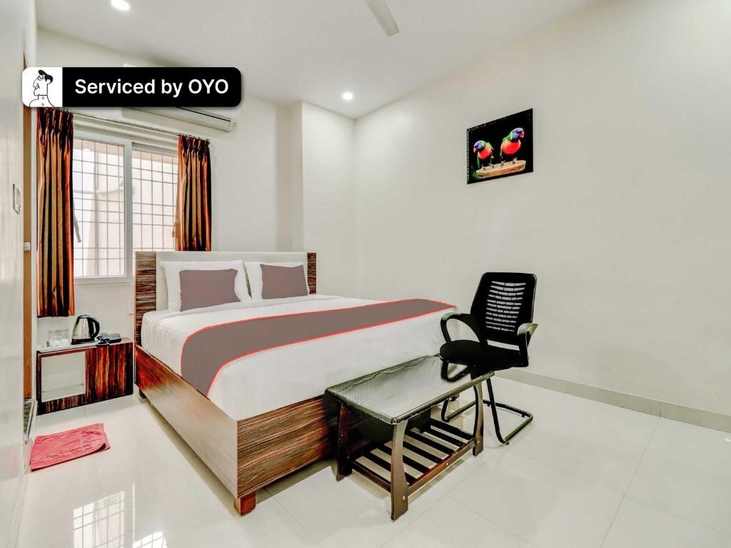 a bedroom with a bed and a desk and a chair at Super Collection O Green Tree Near Beach Road in Alipur