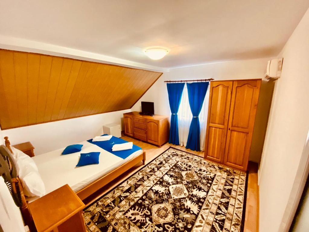 a bedroom with a bed with blue pillows at HANUL PESCARILOR Mila 23 in Mila Douăzeci şi Trei