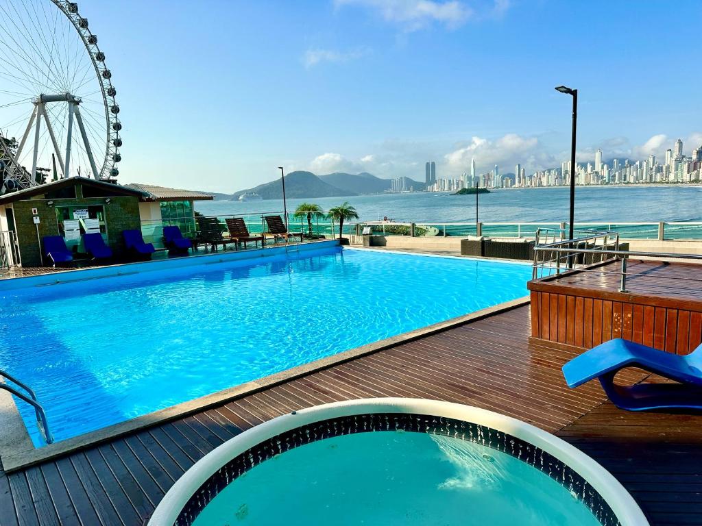 Una gran piscina con vista al agua. en Studio Pé na Areia II, en Balneário Camboriú