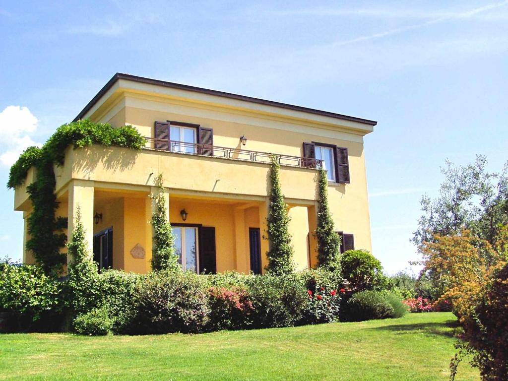 a yellow house with ivy on the side of it at Villa Montecasciano in Capranica