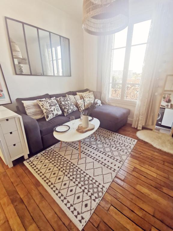 un salon avec un canapé et une table dans l'établissement Charmant appartement à 10 mn de Paris, à Maisons-Alfort