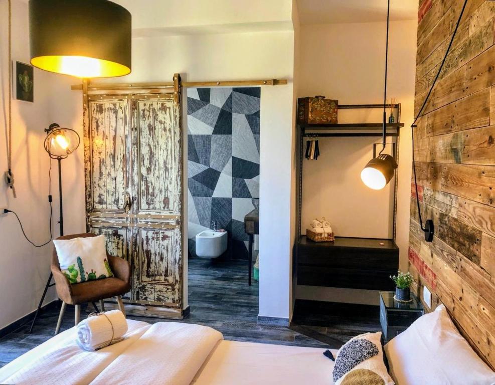 una camera con letto e sedia e un bagno di S'accabbadora Guest House ad Alghero
