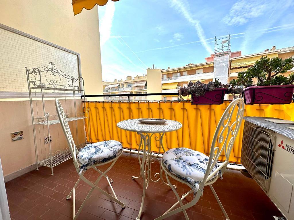 un patio avec une table et des chaises sur un balcon dans l'établissement Cosy 2 pièces au calme avec balcon dans le centre ville, à Menton