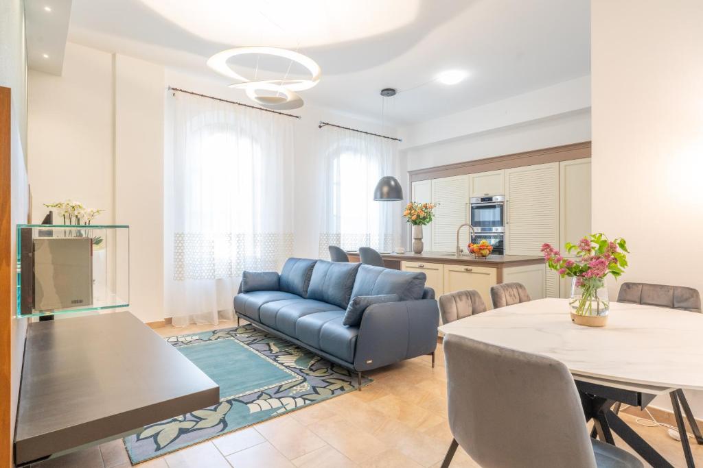 a living room with a blue couch and a table at Antico Borgo 7 - Elegant Apartment Walking Distance to Montepulciano Historic Centre in Montepulciano