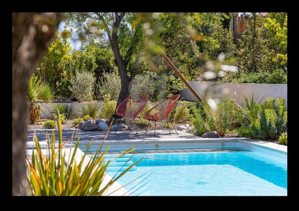 deux chaises assises à côté d'une piscine dans l'établissement Au pied des Alpilles villa 3 chambres, à Saint-Rémy-de-Provence