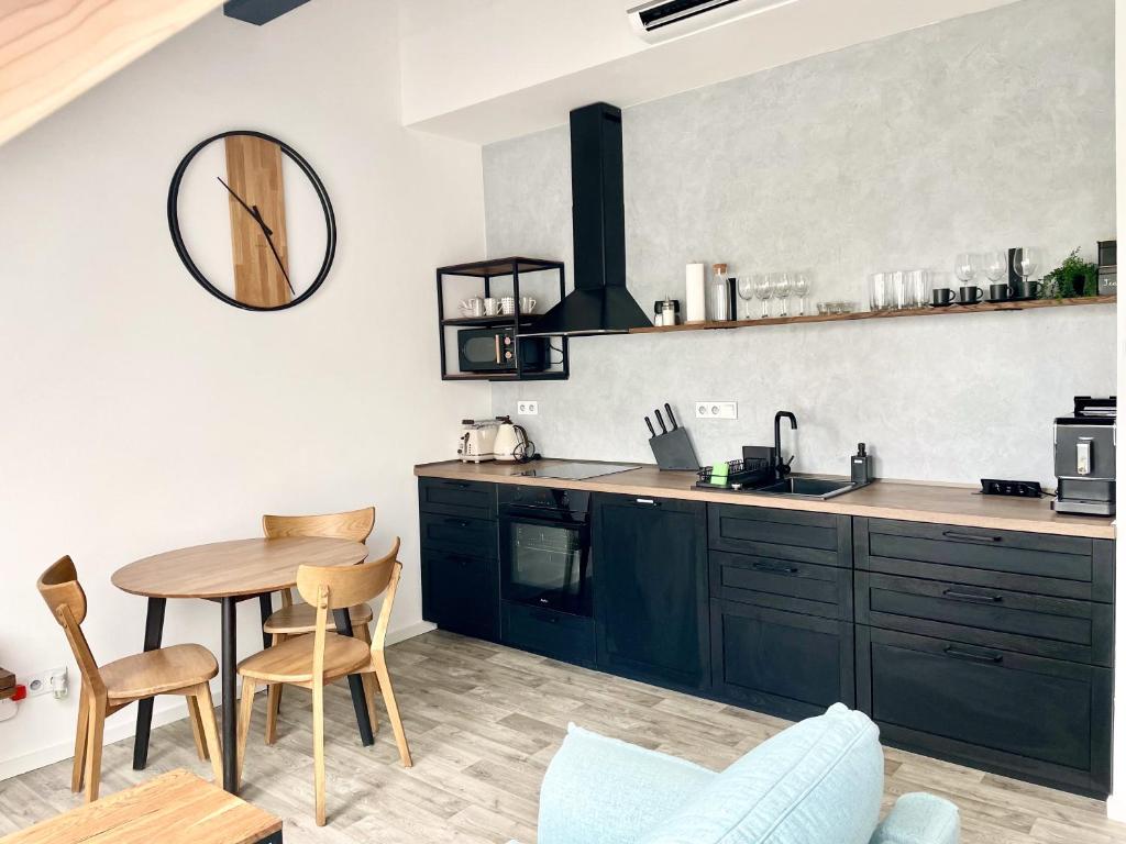 uma cozinha com armários pretos, uma mesa e um espelho em Apartmán Bella em Mikulov