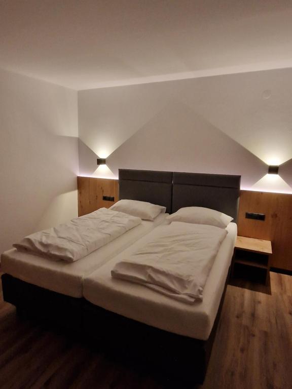 a large bed in a bedroom with two lights at Haus Rätikon in Brand