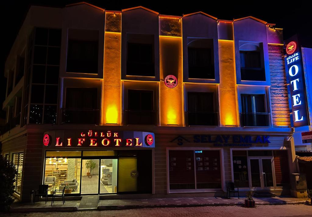 a building with a lit up sign in front of it at Gulluk Life Hotel in Gulluk