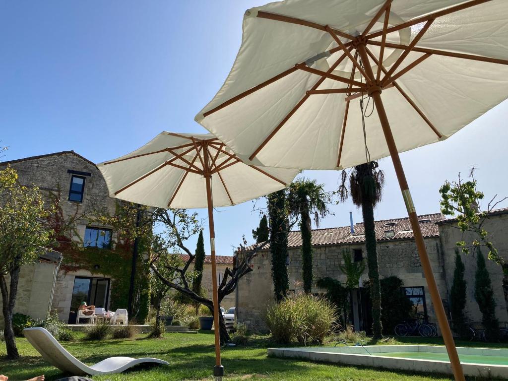 deux parasols et des chaises dans une cour dans l'établissement Maison Mercy, à Saint-Gervais