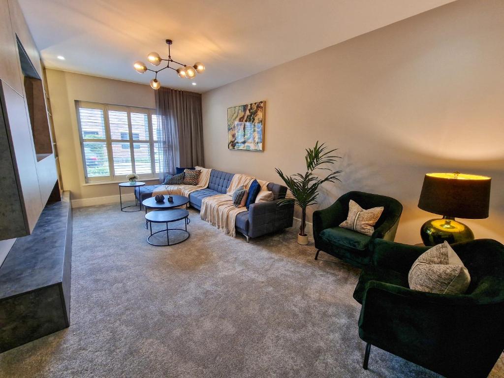 ein Wohnzimmer mit einem Sofa und Stühlen in der Unterkunft Luxury 5* Didsbury Family Home in Manchester