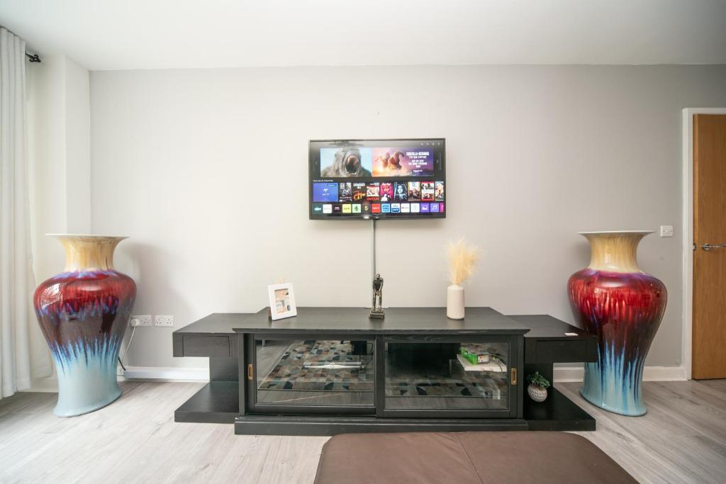 - un salon avec 2 vases et une télévision dans l'établissement A Stylish One-Bedroom Next to London Museum!, à Colindale
