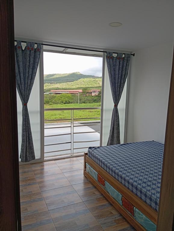 ein Schlafzimmer mit einem Bett und einem großen Fenster in der Unterkunft Casa en curiti in Curití