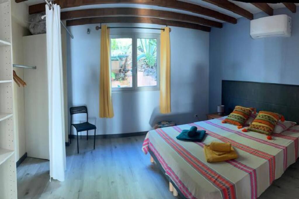 a bedroom with a large bed and a window at Villa Le Coin de Paradis in Saint-Leu