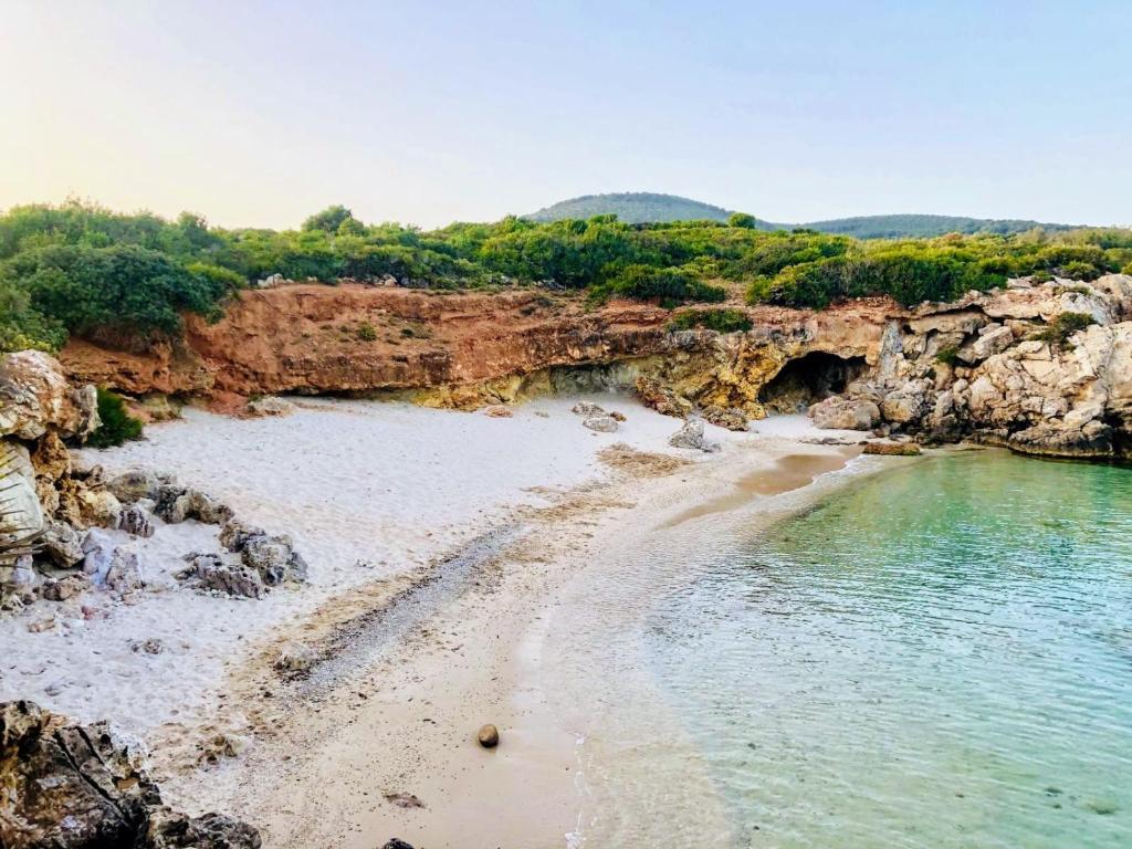 een uitzicht op een strand met rotsen en water bij S'accabbadora Guest House in Alghero