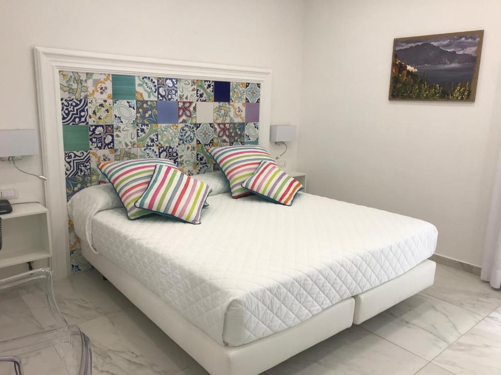 a bedroom with a bed with two pillows on it at Amalfi Suite Boutique Hotel in Amalfi