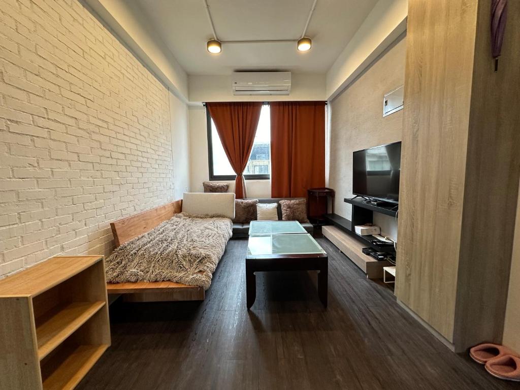 uma sala de estar com um sofá e uma televisão em 基隆3房8到9人房 em Ruifang