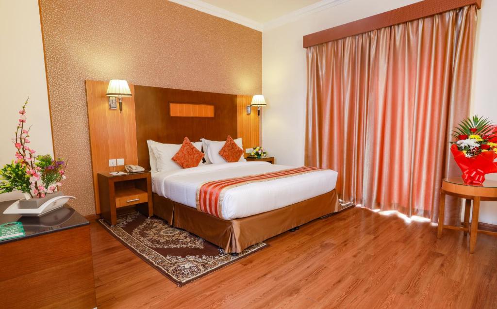 a hotel room with a bed and a window at Fortune Pearl Hotel in Dubai