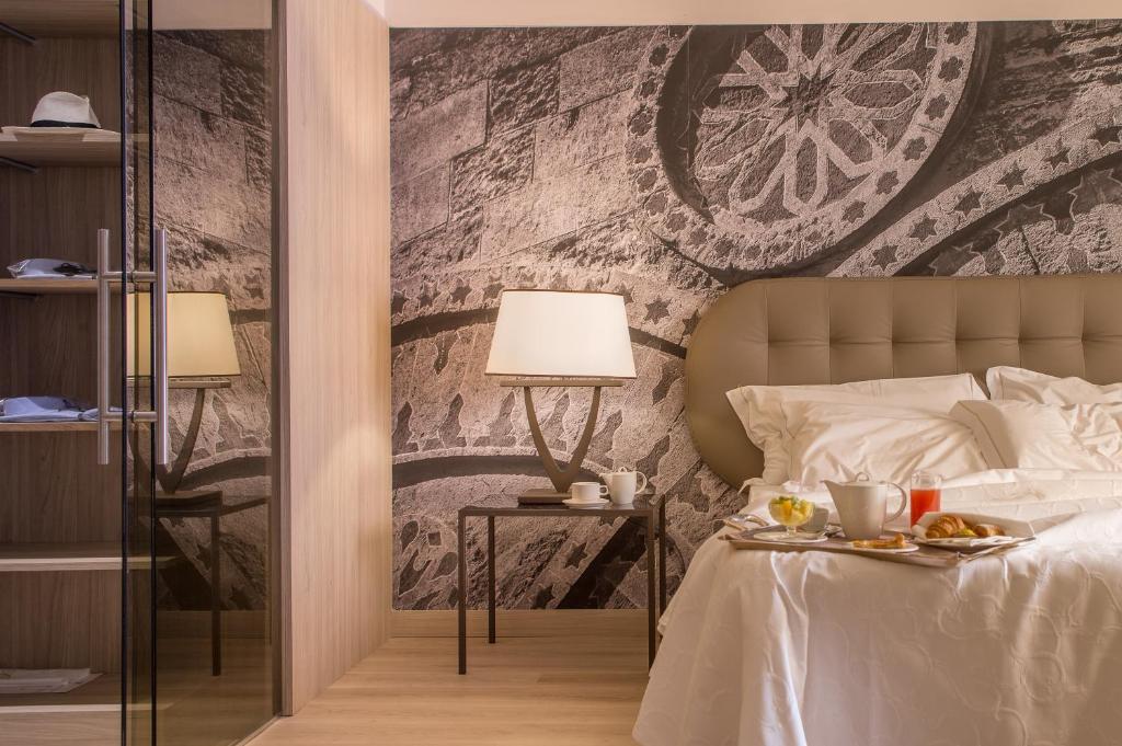 Un dormitorio con una cama con una bandeja de comida. en Hotel Federico II Central Palace, en Palermo