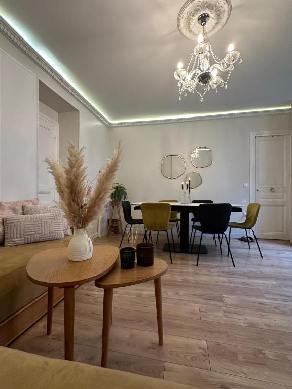 un salon avec une table et un lustre dans l'établissement Apparemment au bord de Paris, à Levallois-Perret