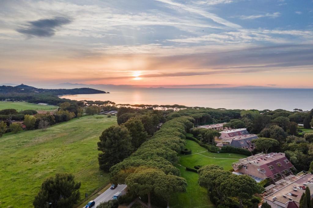 an aerial view of a resort with the sun setting over the water at Residence Scoglietto 50 in Punta Ala