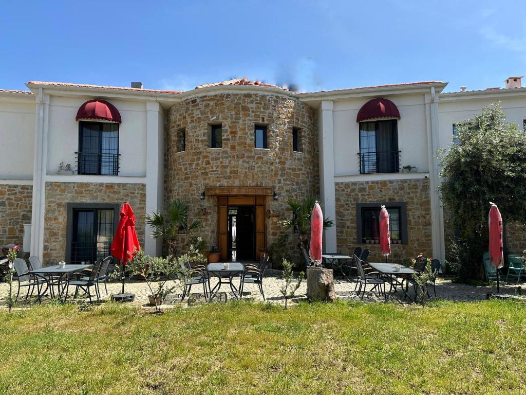 a building with tables and chairs in front of it at Hotel Panaya in Gokceada Town