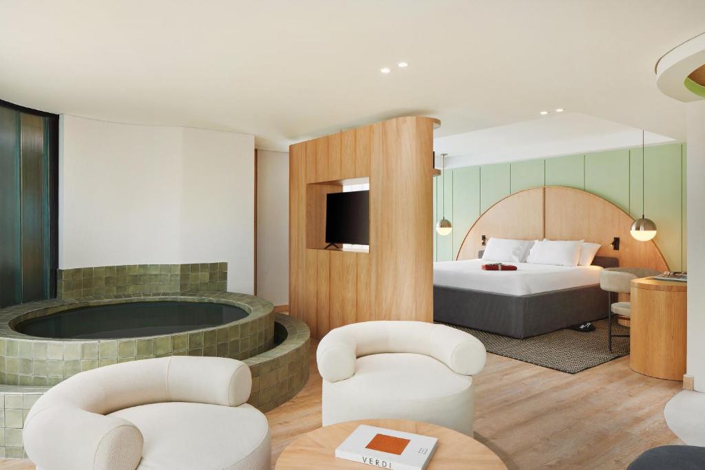 a hotel room with a bed and a tub at Wellcomm Spa & Hotel in Medellín