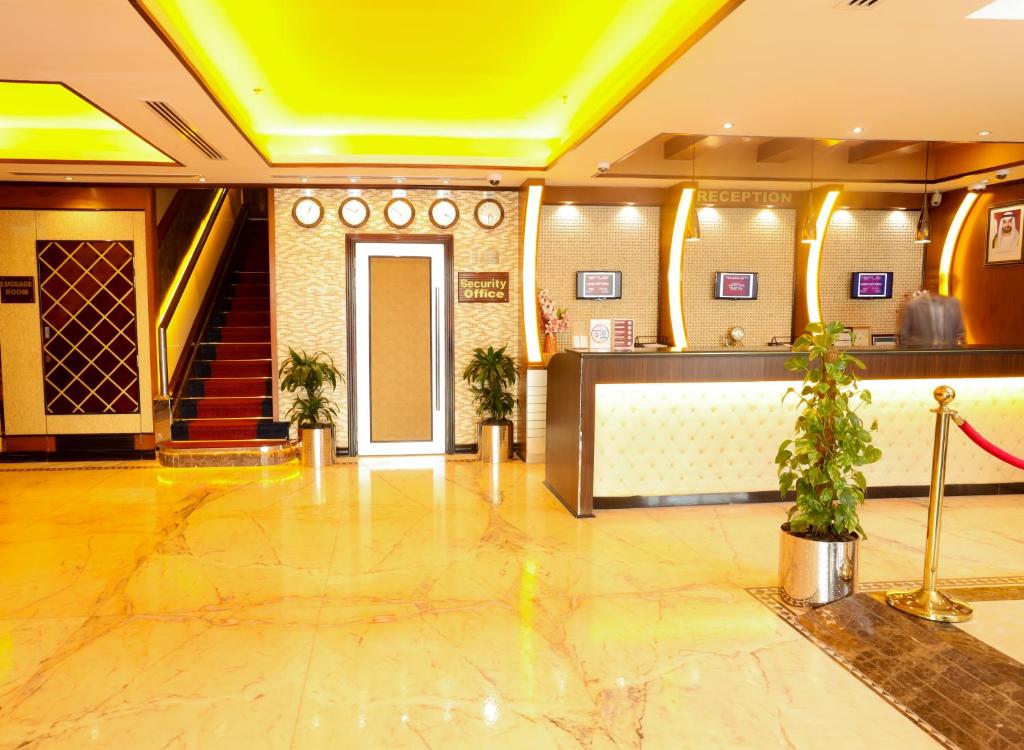 a lobby of a hotel with a staircase and a door at Fortune Pearl Hotel in Dubai
