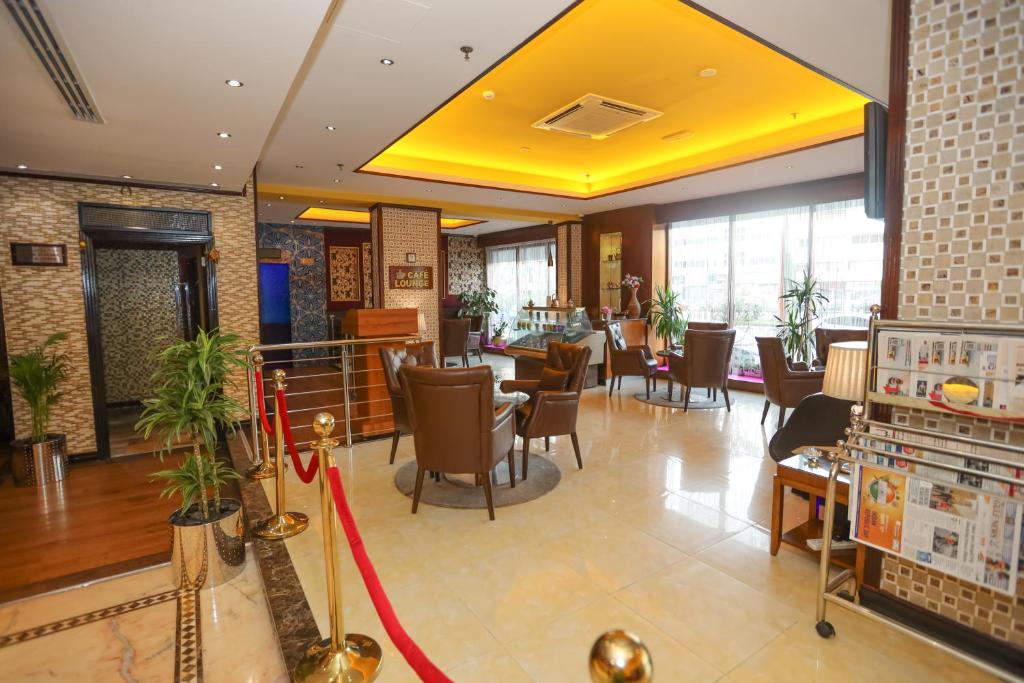 a restaurant with chairs and tables in a lobby at Fortune Pearl Hotel in Dubai