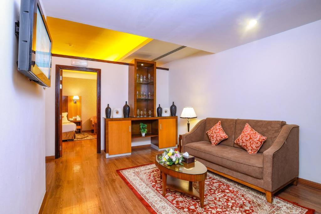 a living room with a couch and a table at Fortune Pearl Hotel in Dubai