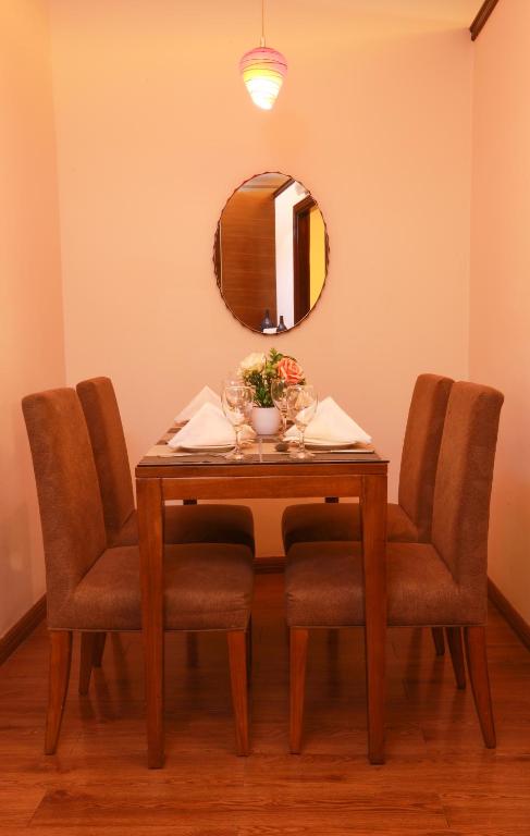a dining room table with chairs and a mirror at Fortune Pearl Hotel in Dubai